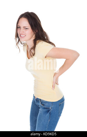 Portrait de jeune femme ayant des douleurs dans son dos sur fond blanc Banque D'Images