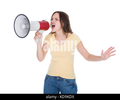 Portrait d'une jeune femme crier par mégaphone sur fond blanc Banque D'Images