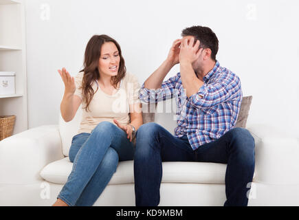 Portrait de frustrés Couple Sitting on Couch se quereller les uns avec les autres Banque D'Images