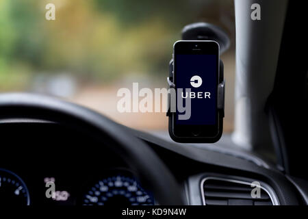 L'intérieur d'un Uber taxi avec un iPhone sur le pare-brise de la voiture avec le logo de l'entreprise. Banque D'Images