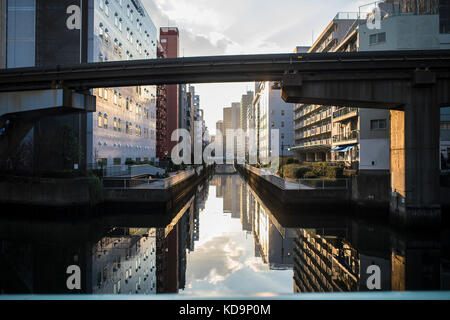 Magnifique coucher de soleil derrière les toits de Tokyo avec des bâtiments reflètent dans la rivière. Banque D'Images