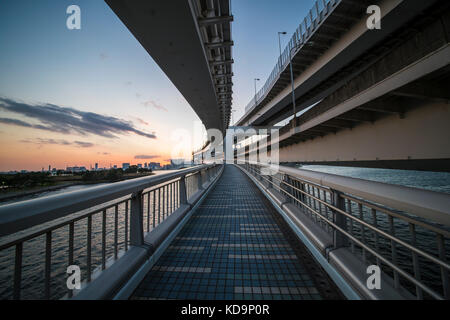 Vue d'un beau coucher de soleil derrière les toits de Tokyo. Photo prise depuis le pont en arc-en-ciel qui relie Tokyo à l'île d'Odaiba. Banque D'Images