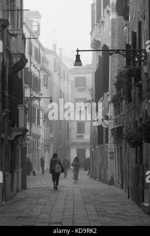 Venise, Italie. 11 octobre, 2017. (Photos a été réalisée en noir et blanc) citizen à pied dans une rue pendant un matin brumeux à Venise, Italie. Dans cette période à Venise commence le premier matin brumeux. © simone padovani / éveil / alamy live news Banque D'Images