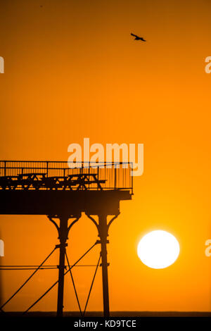 Aberystwyth pays de Galles Royaume-Uni, mercredi 11 octobre 2017 Météo britannique : à la fin d'une journée de mer orageuse , de fortes pluies et de vents de force de vent, le temps a changé de teint, avec le soleil se couchant dramatiquement sur le contour silhouette de la jetée balnéaire de l'ère victorienne d'Aberystwyth photo © Keith Morris / Alamy Live News Banque D'Images