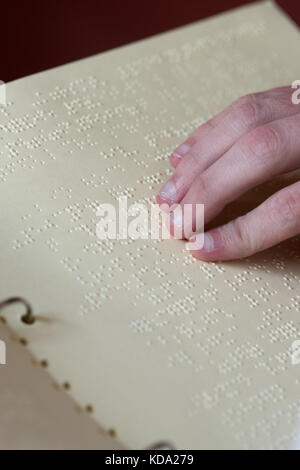 Le juge honoraire aveugle, Florian Schurbesmann, lisant un recueil de statuts en braille dans une salle d'audience de la Cour sociale de Ratisbonne, Allemagne, 11 octobre 2017. Photo: Armin Weigel/dpa Banque D'Images