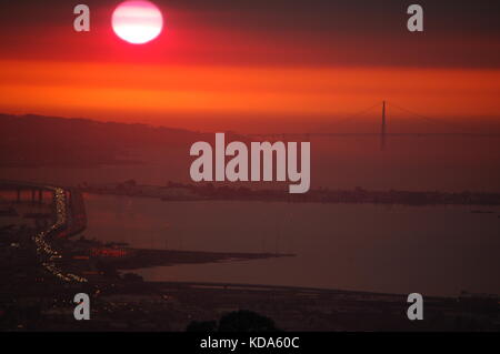 San Francisco, Californie, USA. Oct 11, 2017. La fumée des incendies de Napa et Sonoma couvre San Francisco, Oakland, le Golden Gate Bridge et le Bay Bridge au coucher du Soleil, San Francisco, CA Crédit : Peter Graham/Alamy Live News Banque D'Images