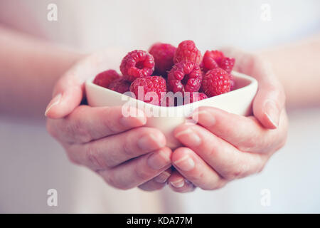 De la vaisselle avec des framboises dans femme mains, selective focus Banque D'Images