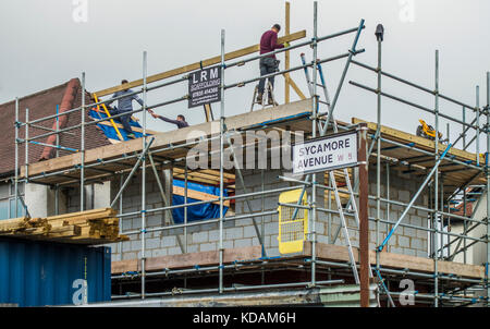 Les constructeurs, entouré par un échafaudage, travaillant à l'étage supérieur d'une maison d'angle à deux étages, l'extension dans le sud ouest de Londres, Ealing, W5, Angleterre, Royaume-Uni. Banque D'Images