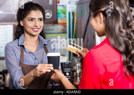 La clientèle féminine pour payer avec carte de crédit café Banque D'Images