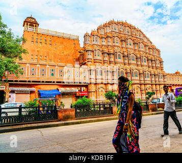 Une jeune femme indienne en sari aux couleurs vives et un indien marchant devant le palais des vents à Jaipur, Inde Banque D'Images