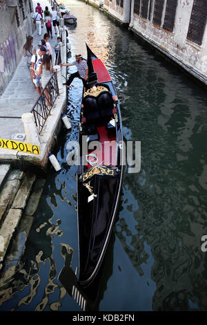 Gondolier avec sa cabine dans les petits canaux de Venise, se préparer pour le suivant les clients Banque D'Images