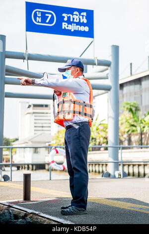 Un port guides officiels les touristes et navetteurs locale thaïlandaise sur et hors le ferry qui traverse la rivière Chao Phraya à Bangkok en Thaïlande. Banque D'Images