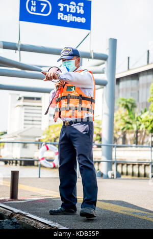 Un port guides officiels les touristes et navetteurs locale thaïlandaise sur et hors le ferry qui traverse la rivière Chao Phraya à Bangkok en Thaïlande. Banque D'Images