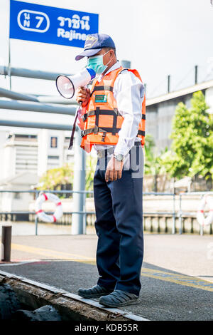 Un port guides officiels les touristes et navetteurs locale thaïlandaise sur et hors le ferry qui traverse la rivière Chao Phraya à Bangkok en Thaïlande. Banque D'Images