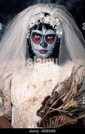 Portrait d'une jeune mariée avec un comté du maquillage, le port de voile et diadème, tenant un bouquet de fleurs fanées Banque D'Images