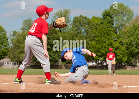 Garçon d'entrer dans base durant un match de baseball avec filtre style Instagram Banque D'Images