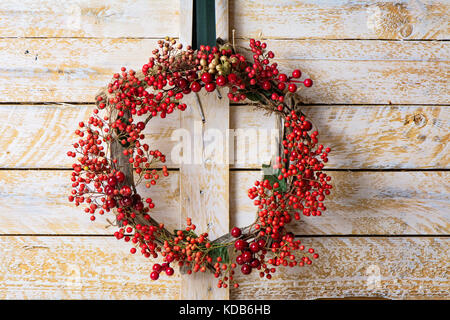 Couronne de Noël d'evergreen et de baies sur fond de bois naturel et réseau nandian. bois rustique couronne Banque D'Images