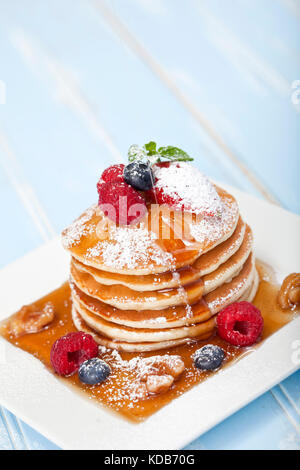 Pile de crêpes avec du sirop d'érable et fruits des champs Banque D'Images