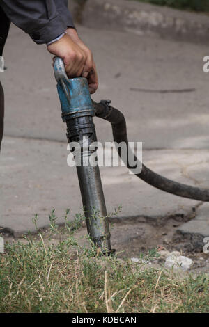 La réparation de la route fonctionne avec jackhammer. travailleur masculin à l'aide de marteau perforateur marteau pneumatique machines sur la réparation des routes. Banque D'Images