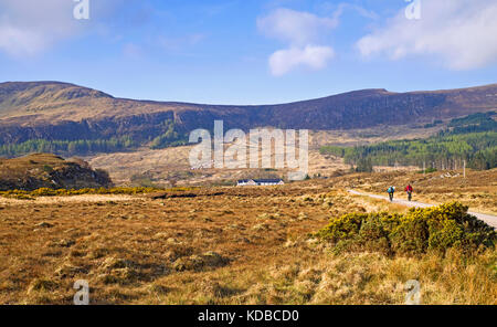 Un couple à vélo sur une petite route tranquille dans les landes campagne sur un beau matin de printemps. Achfary, Sutherland, Highlands écossais au Royaume-Uni. Banque D'Images