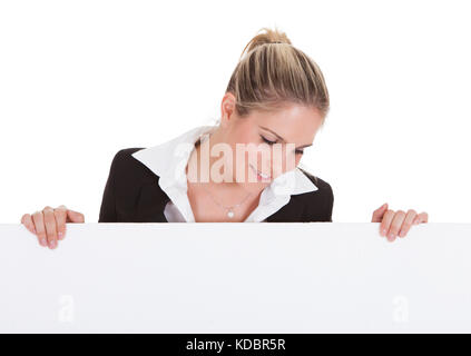 Happy young businesswoman holding vide placard sur fond blanc Banque D'Images