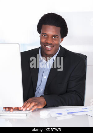 Happy businessman working on computer in office Banque D'Images