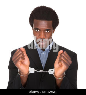 Jeune homme africain avec les mains menottées isolé sur fond blanc Banque D'Images