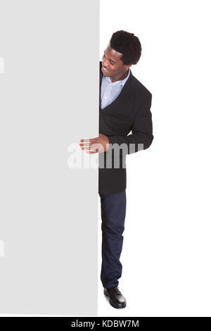 Happy African businessman standing on White Background à la plaque-étiquette à Banque D'Images