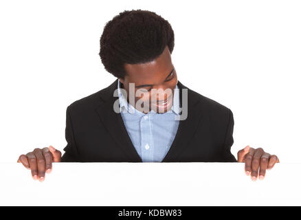 Happy African businessman standing on White Background à la plaque-étiquette à Banque D'Images