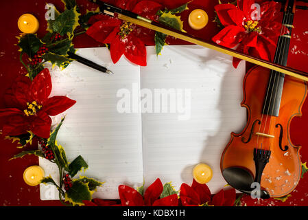 Violon et ouvrir le manuscrit sur le fond rouge concept de noël. Banque D'Images