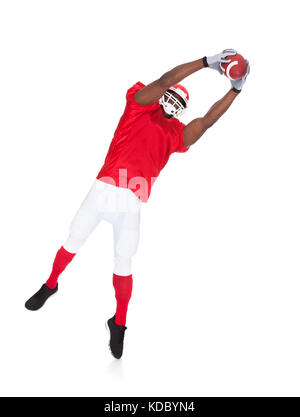 Portrait de joueur de football américain attraper ballon de rugby sur fond blanc Banque D'Images