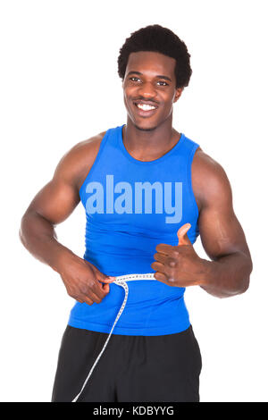Bodybuilder heureux sa taille de mesure showing thumb up sign Banque D'Images