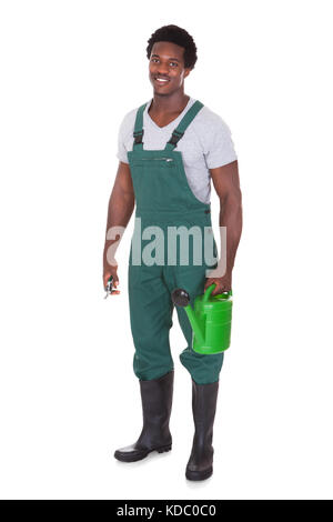 Heureux homme Gardener Holding Watering Can et pinces sur fond blanc Banque D'Images