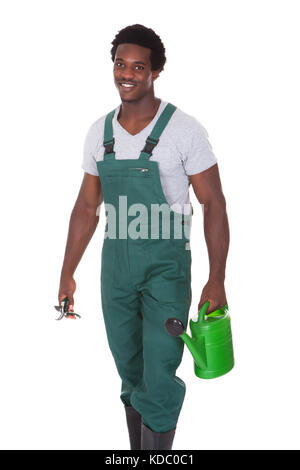 Heureux homme Gardener Holding Watering Can et pinces sur fond blanc Banque D'Images