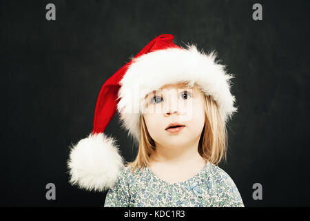 Noël des enfants girl in santa hat rêver sur fond noir