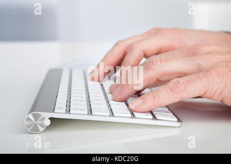 Close-up of person's hand typing sur mot-clé Banque D'Images