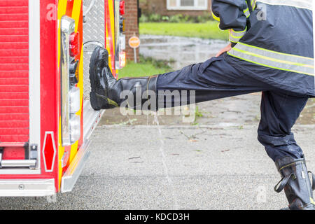 Le premier intervenant de Missouri City Fire Station 4 se vide de ses bottes d'eau. Harvey a causé beaucoup de zones inondées à Houston et sa banlieue Banque D'Images