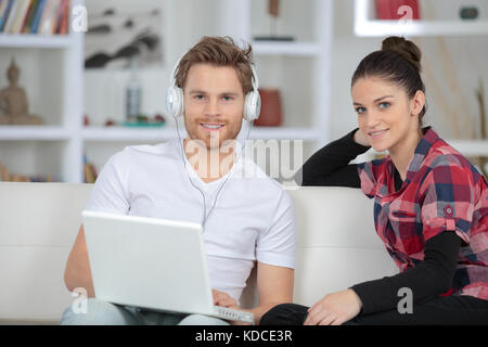 Jeune couple shopping online à la maison sur ordinateur portable Banque D'Images