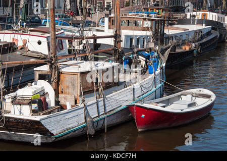 Y compris les bateaux péniches, barges, un skiff et un bateau amarré sur la rivière Amstel à Amsterdam, aux Pays-Bas. Banque D'Images