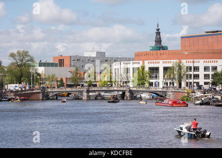 Les bateaux de plaisance sur la rivière Amstel à Amsterdam, avec le Dutch National Ballet et d'Opéra d'Amsterdam dans le centre droit de l'image . Banque D'Images