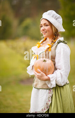 Femme cuisiner un repas de fête pour le jour de la récolte. Image stylisée rétro sur fond de pelouse. Banque D'Images