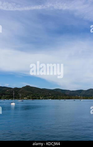 Photo verticale avec Bay sur l'île d'Elbe près du port de Portoferraio. plusieurs bateaux sont sur la mer méditerranée. Roches et colline couverte de bush sont dans b Banque D'Images