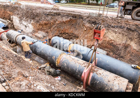 Samara, Russie - 1 octobre, 2017 : travaux de réparation du conduit de chauffage. les travailleurs, les soudeurs faites par soudure électrique sur de gros tuyaux en fer à une profondeur d'excavat Banque D'Images