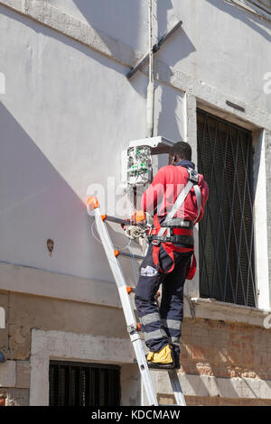 Ingénieur en Télécommunications d'installer de nouveaux câbles à fibre optique pour la haute vitesse à large bande à internet ADSL et téléphoniques sur un extérieur fort sur t Banque D'Images