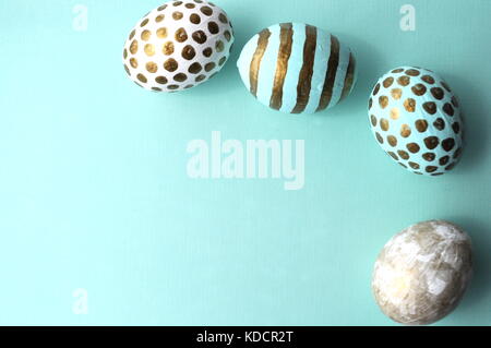Oeufs de Pâques décorés avec de l'or de pois blancs sur fond bleu aqua teal de menthe. Image Style avec copie espace. Thème de Pâques et du printemps. Banque D'Images