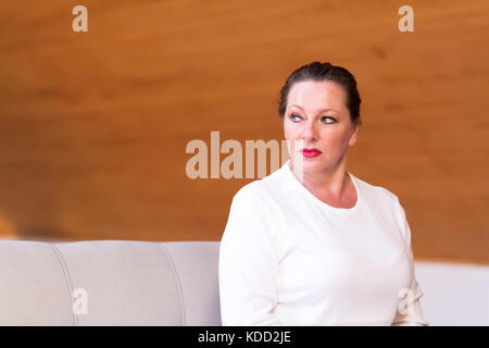 Portrait d'une femme d'âge moyen dans un appartement mansardé en bois. Banque D'Images