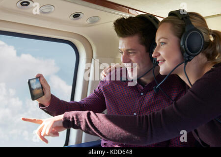 Couple en vacances prenant tour en hélicoptère Banque D'Images