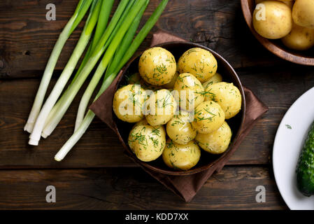 Accompagné de pommes de terre nouvelles avec de l'aneth dans un bol sur fond de bois, vue du dessus Banque D'Images