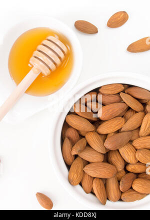 Amandes et miel isolé sur fond blanc Banque D'Images