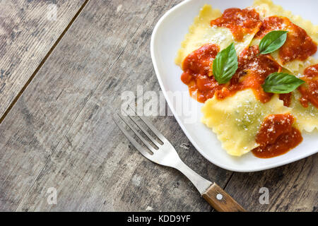 Ravioli à la sauce tomate et basilic sur table en bois Banque D'Images